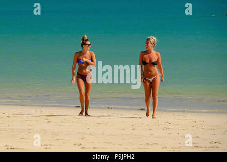 two young women in bikinis walking along Porthminster beach in St Ives, Cornwall Stock Photo