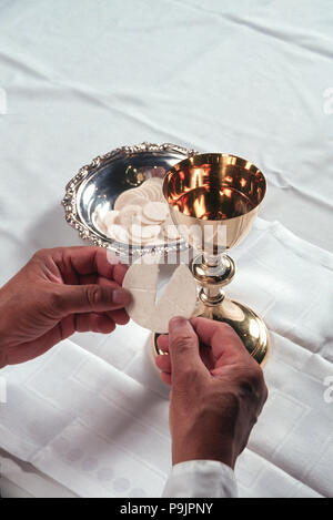 priest breaking host wafer communion  MR  © Myrleen Pearson....Ferguson Cate Stock Photo