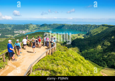 Tourists at a viewpoint over Sete Cidades, two lakes and a village in the dormant crater of a volcano on the island of Sao Miguel, The Azores Stock Photo