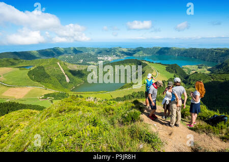 Tourists at a viewpoint over Sete Cidades, two lakes and a village in the dormant crater of a volcano on the island of Sao Miguel, The Azores Stock Photo