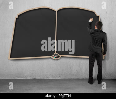 Man writing on book shape blackboard Stock Photo