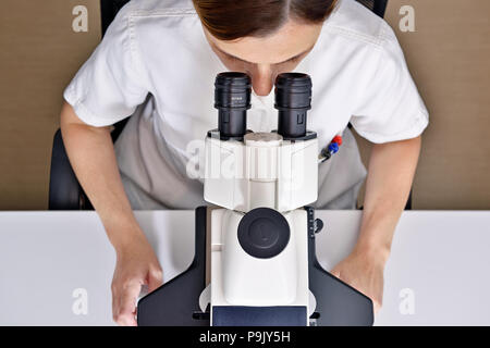 Female Scientist using a Microscope in a Laboratory Stock Photo