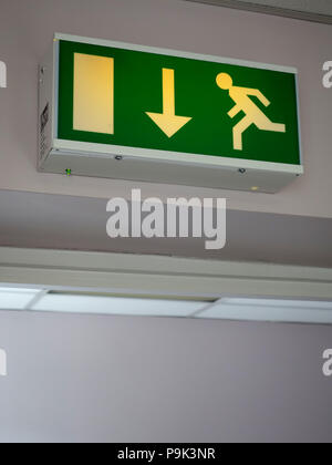Running man icon Emergency exit sign above fire escape from first floor office leading down to outside emergency exterior door Stock Photo
