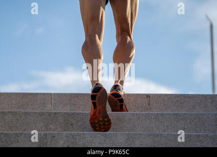 Man runner running on stairs in urban city sport training young male jogger athlete training and doing workout outdoors in city. Fitness and exercisin Stock Photo