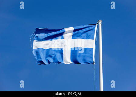 Worn flag of Shetland, white Nordic cross on a blue background, blowing in the wind against blue sky, Shetland Islands, Scotland, UK Stock Photo