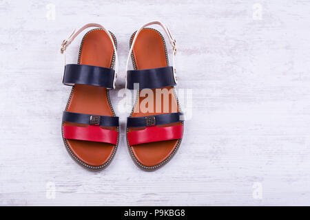 Pair of fashionable women's sandals on white wooden background. Stock Photo