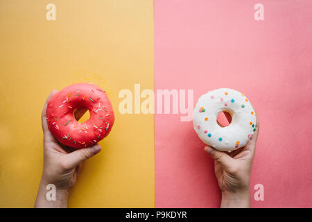 The girl is holding two donuts in her hands. Stock Photo