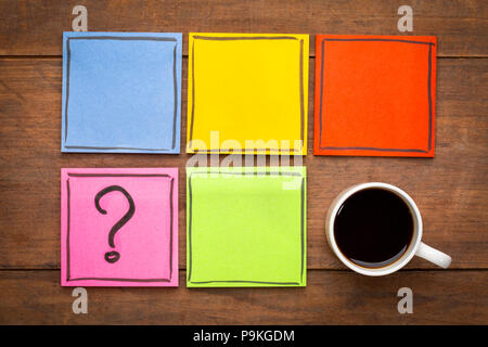 question mark and blank reminder notes - handwriting on colorful sticky notes with a cup of coffee Stock Photo