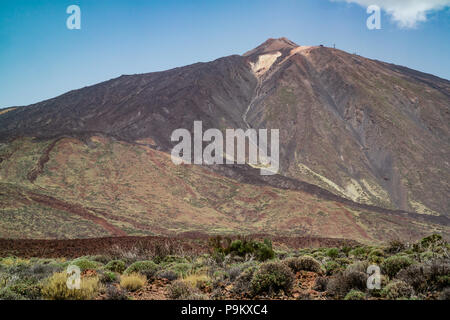 Mount Teide, a decade volcano in Tenerife, with arid scrubland and lava rocks in the foreground of the landscape. Stock Photo