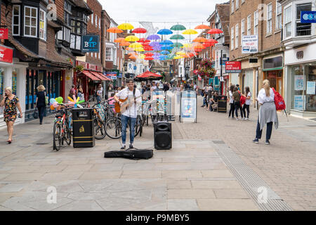 Busker and colourful umbrellas in Salisbury High Street Stock Photo
