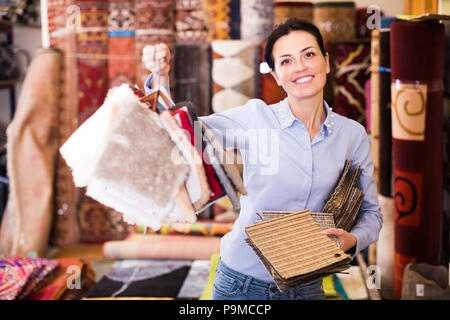 Female choosing carpet samples in the store before the buying Stock Photo