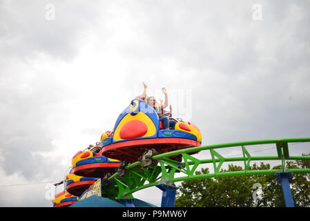 State fair carnival ride with kids laughing and having fun Stock Photo