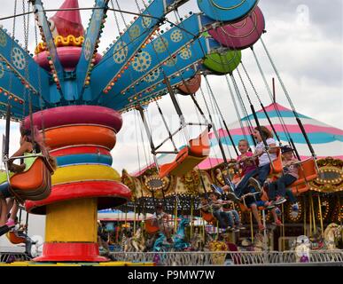 State fair carnival ride with kids laughing and having fun Stock Photo