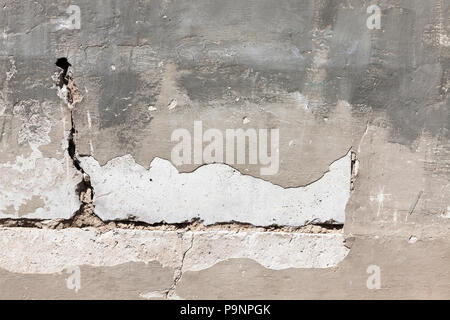 struck plaster on the wall of a building made of large reinforced concrete slabs, a photo of a close-up of the details of the structure Stock Photo