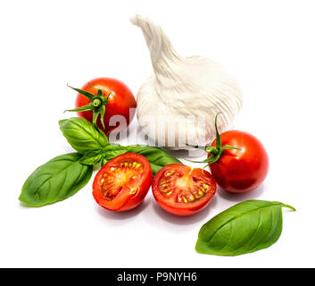 Two whole fresh red cherry tomatoes, two cherry halves, fresh green basil leaves and one garlic isolated on white background Stock Photo