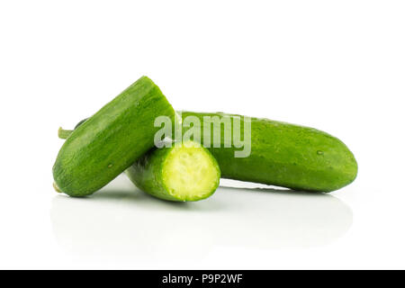 Sliced fresh green mini cucumbers one whole and two halves isolated on white background Stock Photo