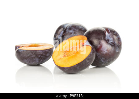 Two red blue plums and two halves isolated on white background Stock Photo