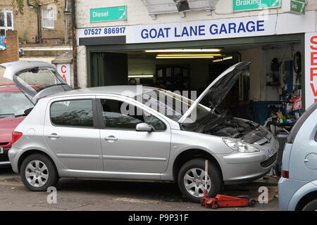 A car being fixed at a small garage at Goat Lane, Basingstoke. Stock Photo