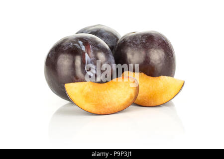 Three red blue plums and two slices isolated on white background Stock Photo