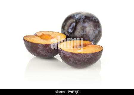 Red blue plums one whole and two halves isolated on white background Stock Photo