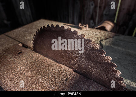 Rusty old circular saw blade in an abandoned workshop. Stock Photo