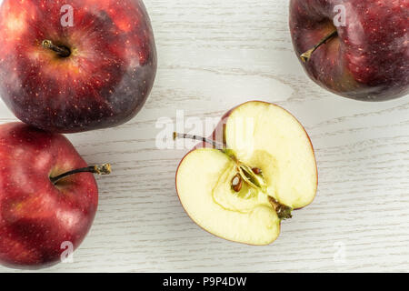 Red delicious three apples and one half flatlay on grey wood background Stock Photo