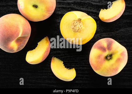 Yellow peaches flatlay collection on black wood background Stock Photo