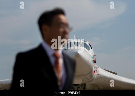 A visitor from Chinese delegation walks near the Tupolev Tu-160 of Russian Air Force at MAKS-2015 airshow near Zhukovsky, Moscow Region, Russia Stock Photo