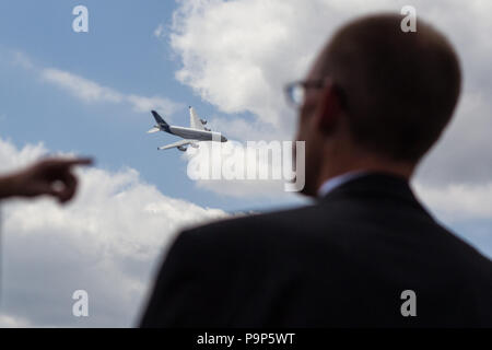 A visitor at the airshow watches the demonstration flight of the Airbus A380 civil airplane at the Farnborough International Airshow, UK Stock Photo