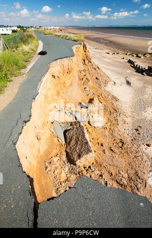 A collapsed coastal road at between Skipsea and Ulrome on Yorkshires East Coast, near Skipsea, UK. The coast is composed of soft boulder clays, very vulnerable to coastal erosion. This section of coast has been eroding since Roman times, with many villages having disappeared into the sea, and is the fastest eroding coast in Europe. Climate change is speeding up the erosion, with sea level rise, increased stormy weather and increased heavy rainfall events, all playing their part. Stock Photo