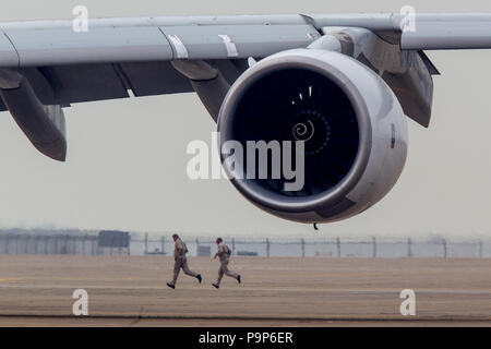 Two men run behind the Rolls-Royce Trent 900 engine at the Airshow China 2014 in Zhuhai, China