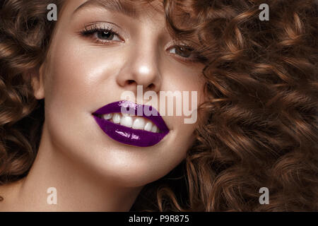 Beautiful girl with evening make-up, purple lips, curls. beauty face. Photos shot in studio. Stock Photo