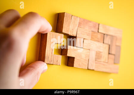 woman hand put wooden blocks arranging stacking for finishing task. Concept of solve problem and success plan. Stock Photo