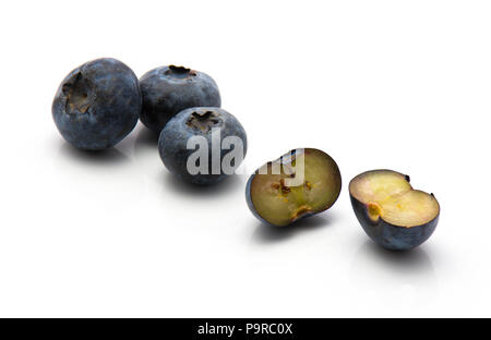 Bog blueberries isolated on white background three whole and one cut in half Stock Photo