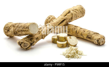 Two whole, one half and freshly grated mash of horseradish root, isolated on white background, sliced circles Stock Photo