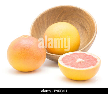 Red grapefruits in a wooden bowl isolated on white background two whole one sliced half Stock Photo