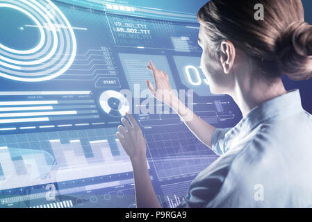 Careful touch. Skilled experienced programmer gently touching the transparent device while working at the new program Stock Photo
