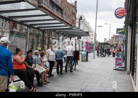 People waiting at a bus stop on Upper Parliament Street in Nottingham City, Nottinghamshire England UK Stock Photo