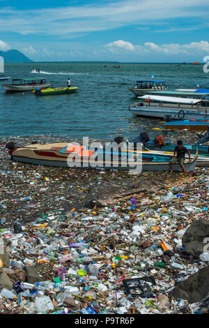 Plastic pollution floating next to small boats at the waterfront in Semporna town in Sabah, (Malaysian Borneo), Malaysia. Stock Photo