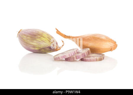 Two shallots one in golden husk and one peeled with three ring slices isolated on white background Stock Photo