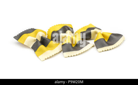 Farfalle pasta with curcuma and cuttlefsh ink isolated on white background raw classic traditional Italian yellow black three pieces Stock Photo