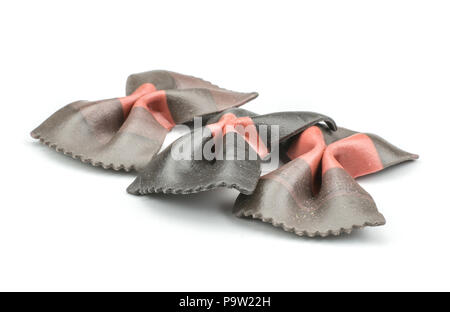 Farfalle pasta with black cuttlefish ink isolated on white background raw classic traditional Italian three pieces Stock Photo