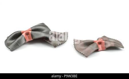 Farfalle pasta with black cuttlefish ink isolated on white background three raw pieces classic traditional Italian Stock Photo