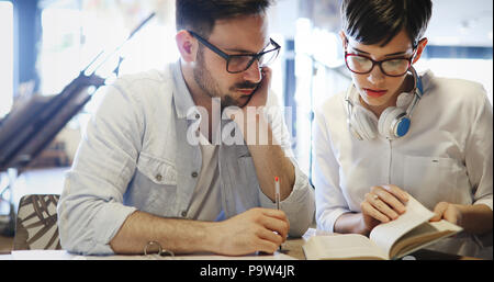 Portrait of students studying in bookstore together Stock Photo