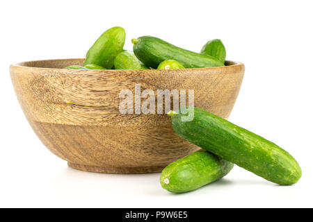 Fresh green mini cucumbers in a wooden bowl two cucumbers are near isolated on white background Stock Photo