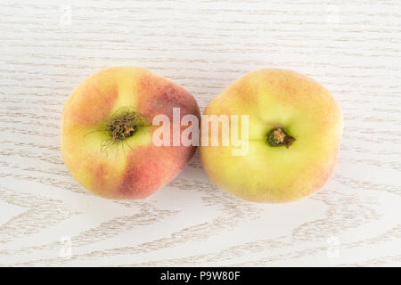 Two fresh ripe Saturn peaches flatlay on grey wood background Stock Photo