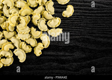 Pasta creste di gallo flatlay isolated on black wood background top view spinach raw Stock Photo