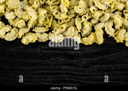 Pasta spinach creste di gallo flatlay isolated on black wood background top view raw Stock Photo