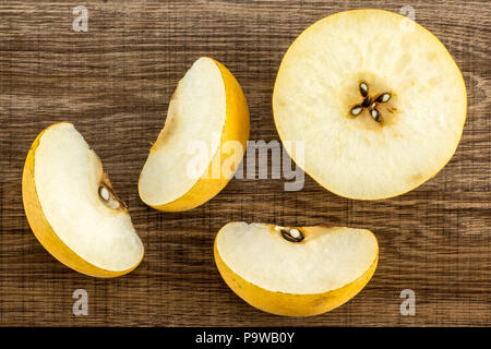 Chinese golden pears top view Nashi variety isolated on wooden background one half three slices Stock Photo