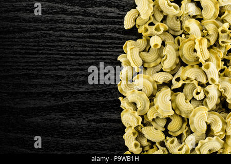 Pasta spinach raw creste di gallo flatlay isolated on black wood background top view Stock Photo
